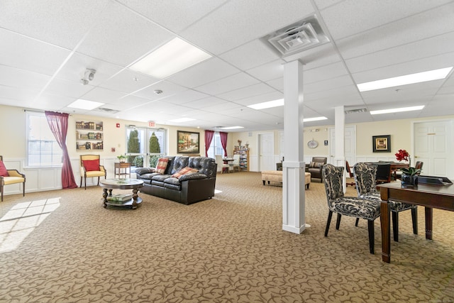 carpeted living room featuring a drop ceiling