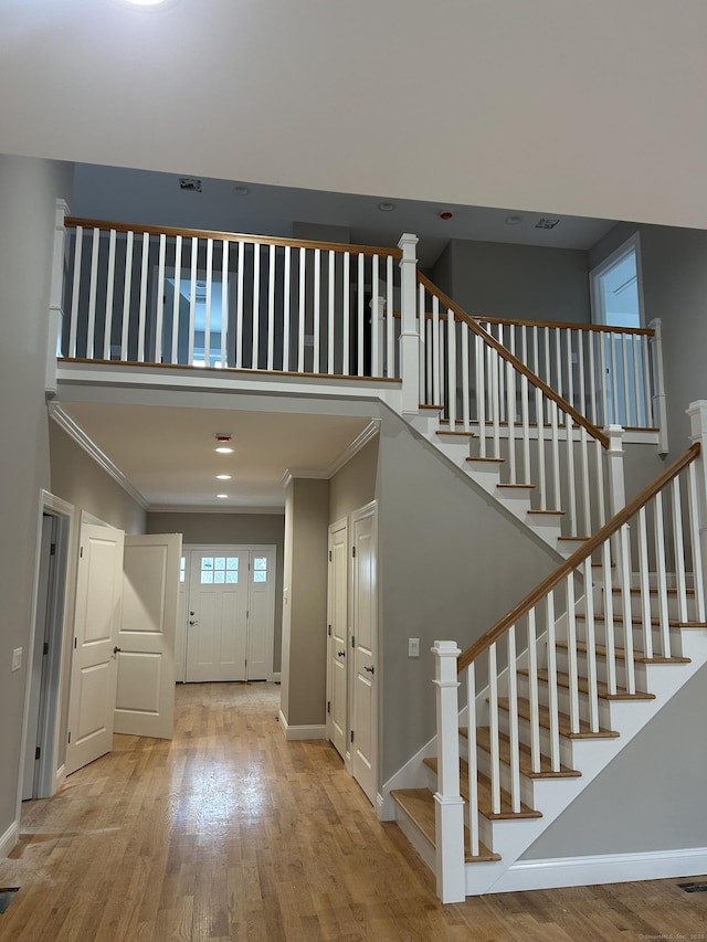 foyer with ornamental molding and light hardwood / wood-style flooring