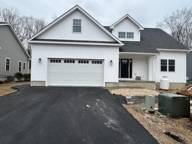 view of front of property featuring cooling unit and a garage