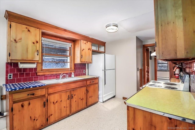 kitchen with white refrigerator, sink, tasteful backsplash, and stove