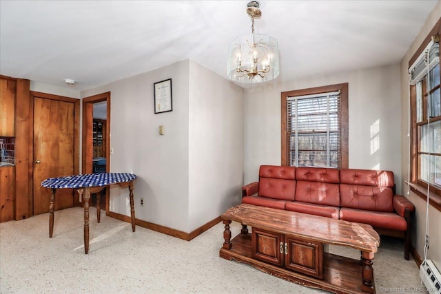 living room featuring a baseboard heating unit and a notable chandelier