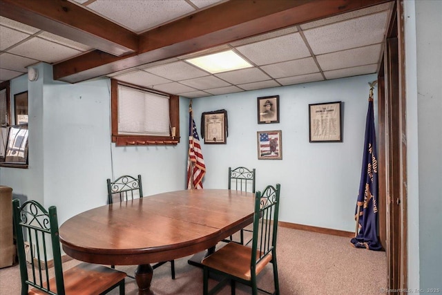 carpeted dining room with a paneled ceiling