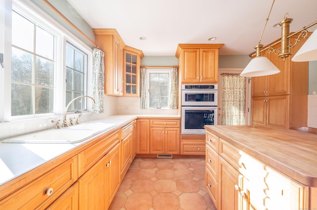 kitchen with pendant lighting, sink, white double oven, tasteful backsplash, and wood counters