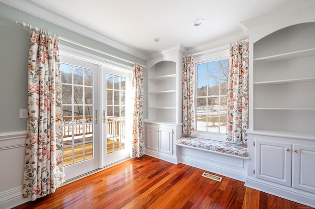 unfurnished dining area featuring french doors, wood-type flooring, ornamental molding, and built in shelves