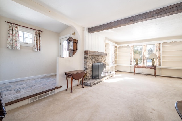 living room with a fireplace, lofted ceiling with beams, and carpet