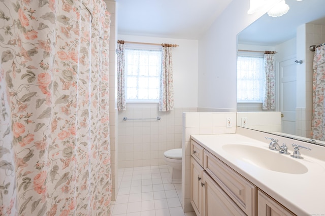 bathroom with plenty of natural light, tile patterned flooring, tile walls, and vanity