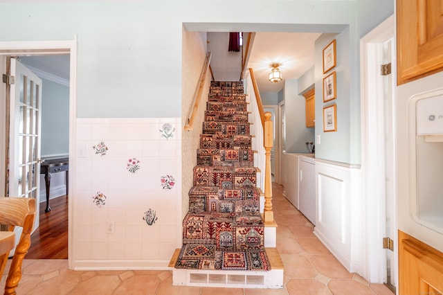 staircase with tile patterned flooring and washing machine and dryer