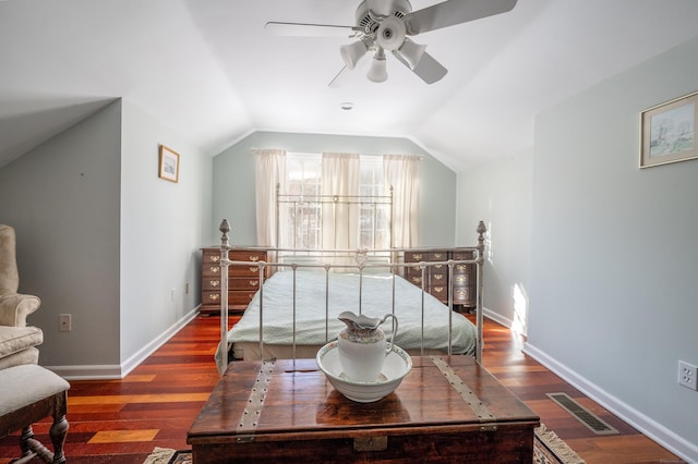 bedroom featuring dark wood-type flooring, vaulted ceiling, and ceiling fan