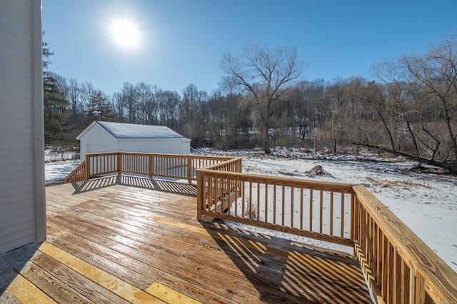 snow covered deck featuring a garage and an outdoor structure