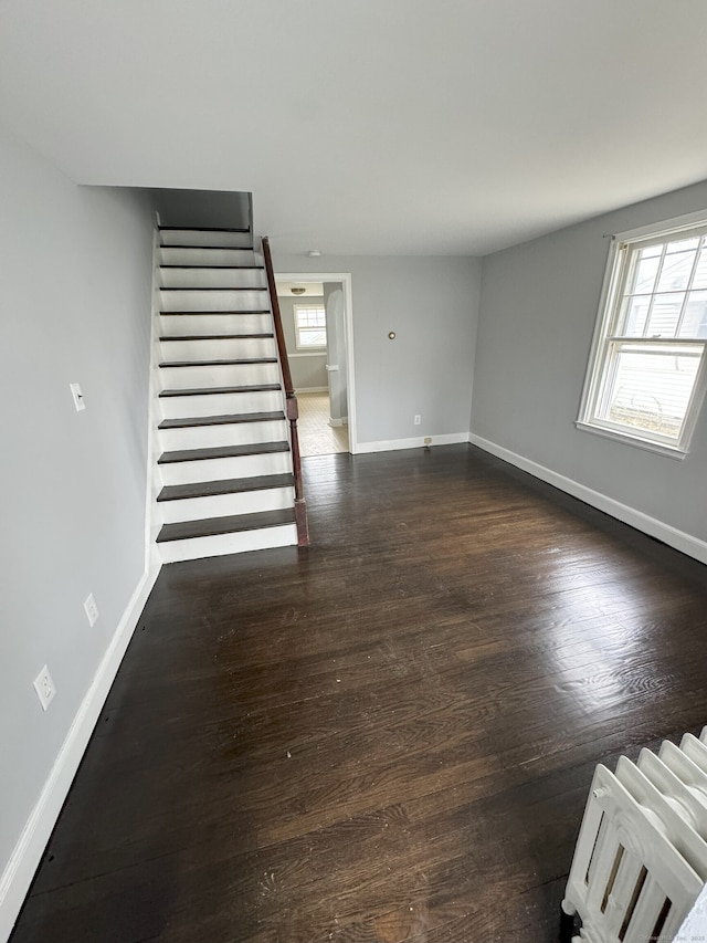 unfurnished living room featuring dark hardwood / wood-style floors