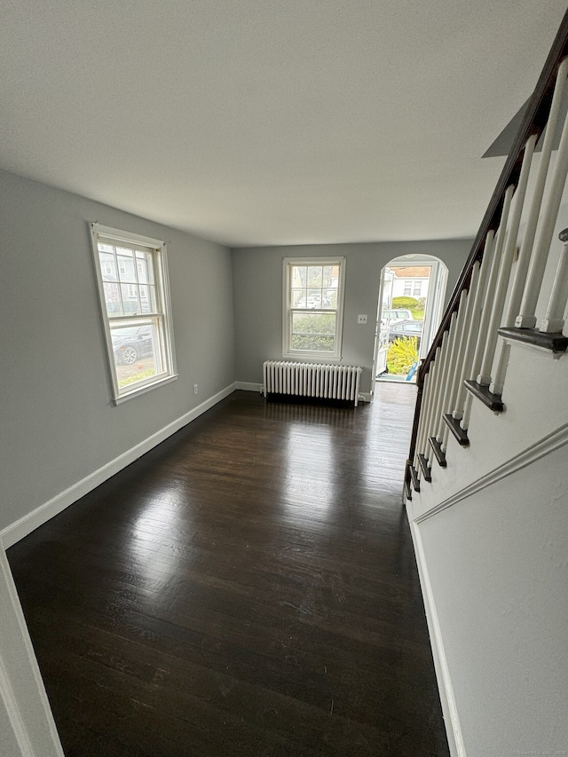 spare room featuring radiator heating unit and dark hardwood / wood-style floors