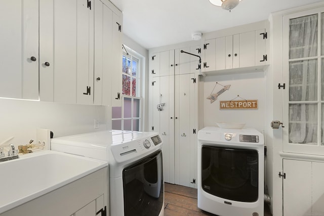 laundry area with cabinet space, washing machine and clothes dryer, and wood finished floors