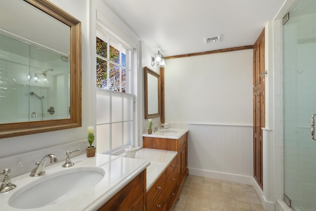 bathroom featuring a stall shower, vanity, and wainscoting