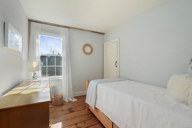 bedroom featuring hardwood / wood-style flooring and baseboards