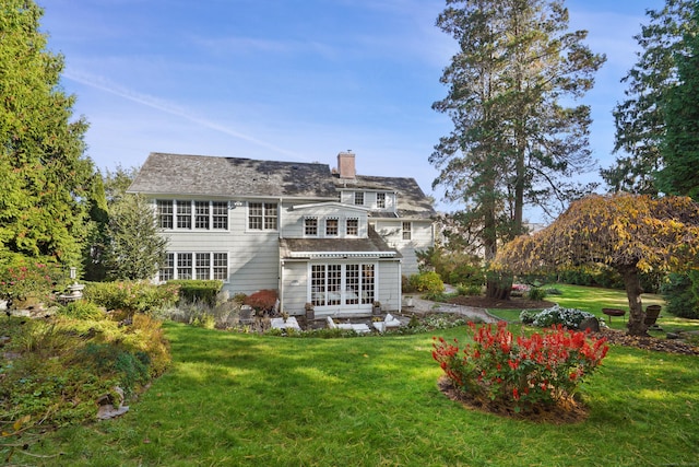 rear view of house with a chimney and a lawn