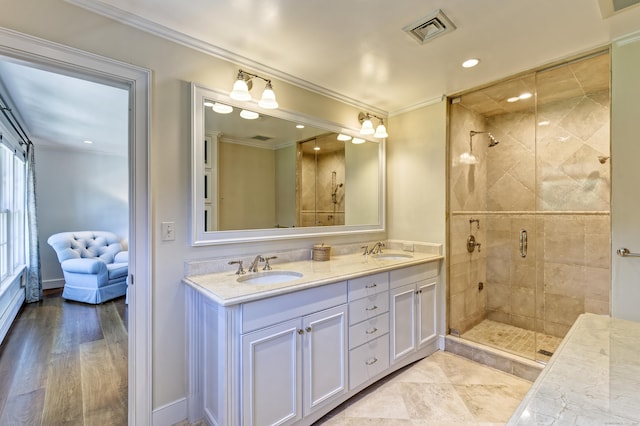 bathroom featuring a shower stall, crown molding, double vanity, recessed lighting, and baseboards