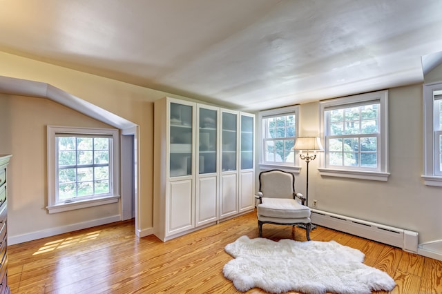 sitting room with a baseboard radiator, light wood-style flooring, and baseboards