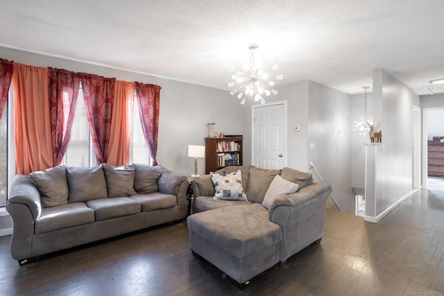 living room featuring an inviting chandelier, dark wood-type flooring, and a textured ceiling