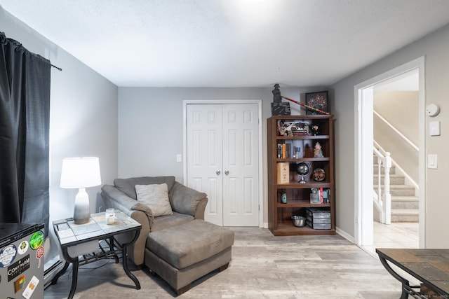 living area featuring light hardwood / wood-style flooring and a textured ceiling