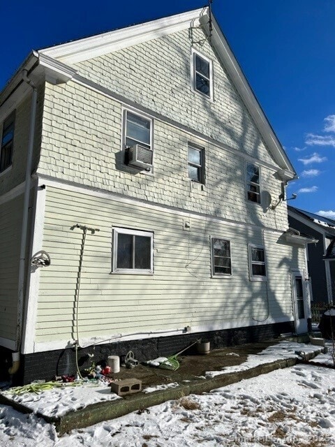 snow covered property with cooling unit