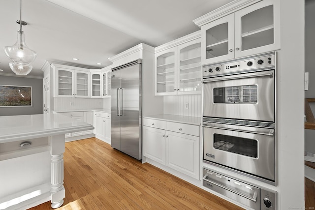 kitchen featuring white cabinetry, crown molding, light hardwood / wood-style flooring, and stainless steel appliances