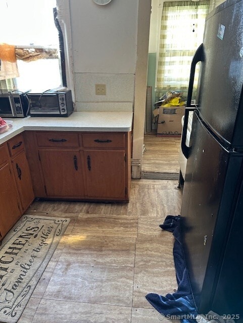 kitchen featuring black refrigerator and a healthy amount of sunlight