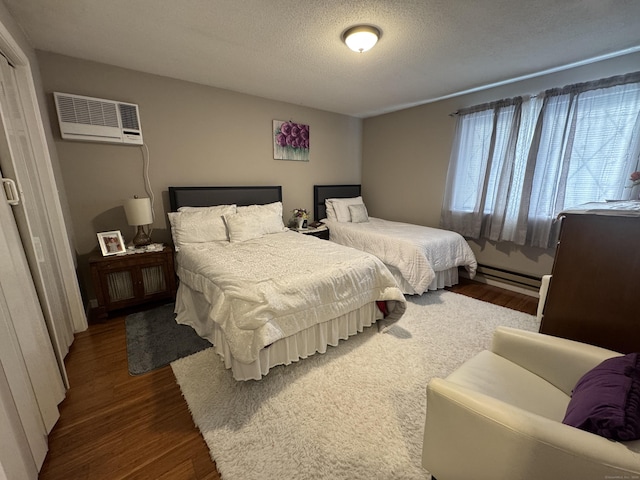 bedroom with dark hardwood / wood-style flooring, a textured ceiling, and a wall mounted AC