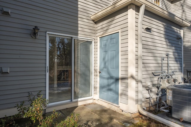 doorway to property with central AC and a patio area