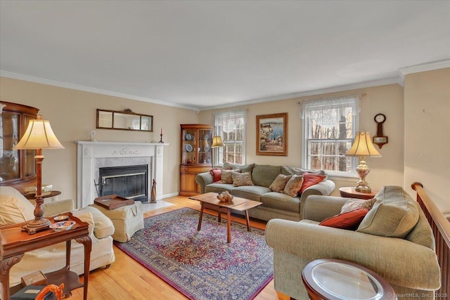 living area with a fireplace with flush hearth, ornamental molding, and wood finished floors