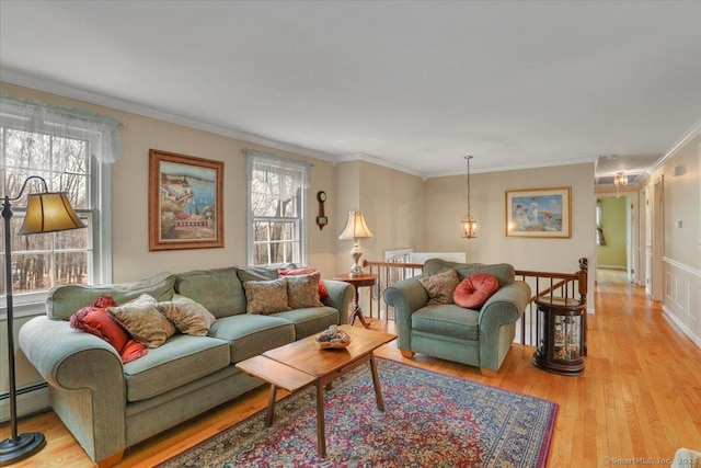 living area with ornamental molding, light wood-type flooring, and a baseboard radiator