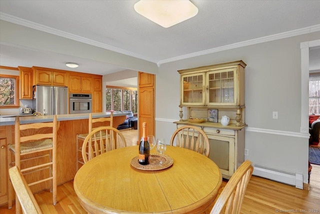 dining room featuring light wood-style floors, a baseboard radiator, and crown molding