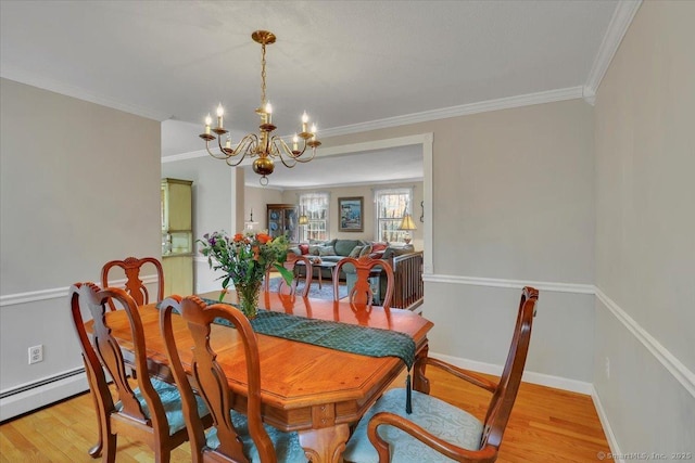 dining area featuring light wood-type flooring, baseboards, a chandelier, and crown molding