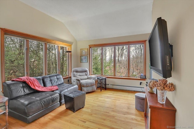 living area featuring lofted ceiling, baseboard heating, and light wood-style floors