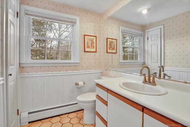 bathroom with baseboard heating, wainscoting, and wallpapered walls