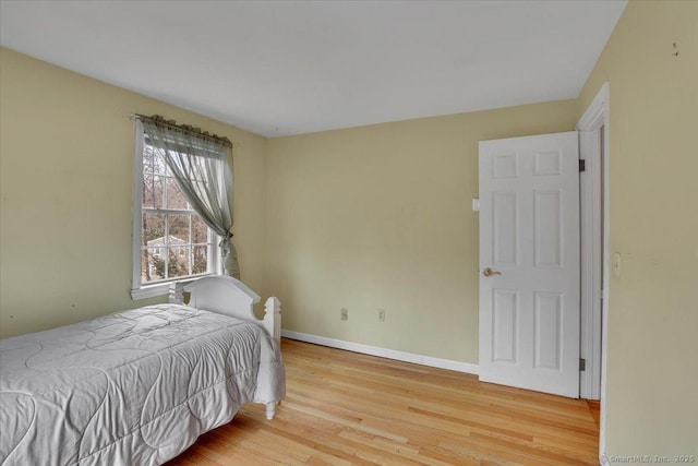 bedroom featuring light wood-style floors and baseboards