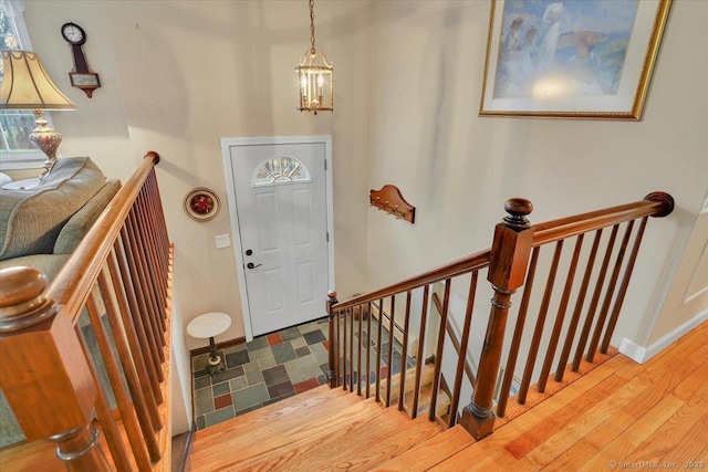 entryway with a notable chandelier, baseboards, and wood finished floors