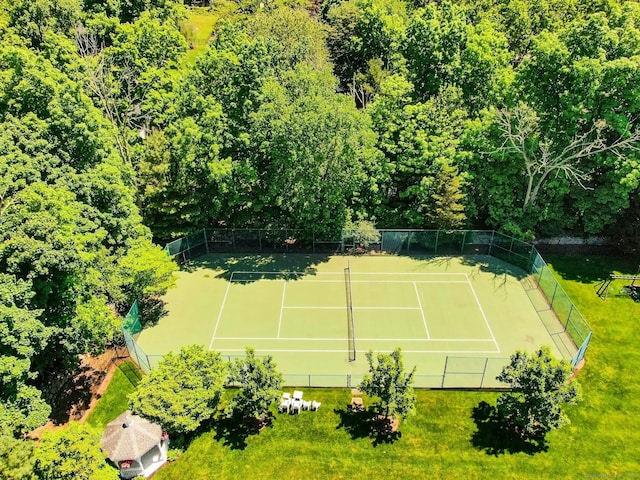 view of tennis court with a yard