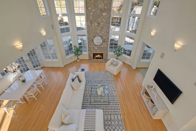 living room featuring a fireplace, hardwood / wood-style floors, and a high ceiling