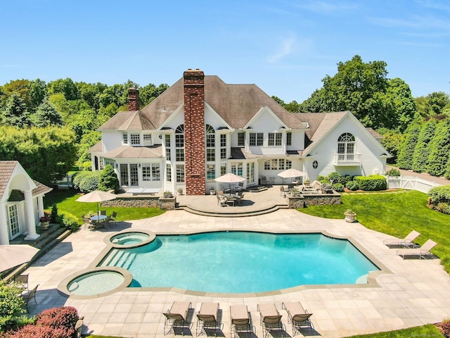 view of swimming pool featuring french doors, an in ground hot tub, a yard, and a patio