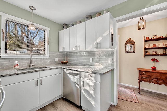 kitchen with sink, white cabinetry, stainless steel dishwasher, pendant lighting, and decorative backsplash