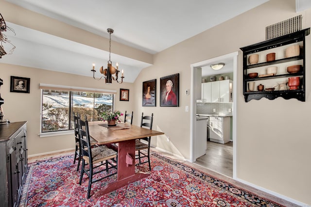 dining space with lofted ceiling and a chandelier