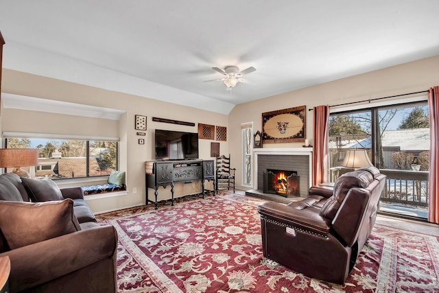 living room featuring a brick fireplace, vaulted ceiling, and ceiling fan