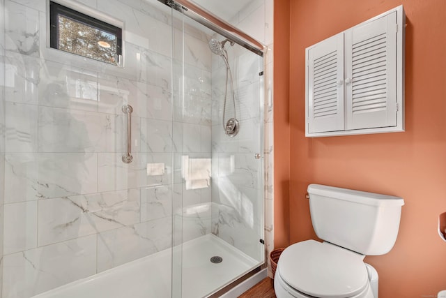 bathroom with an enclosed shower and toilet