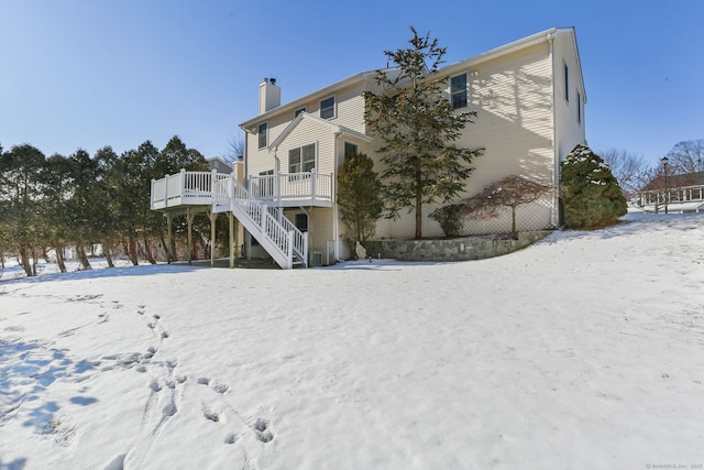 snow covered house featuring a wooden deck