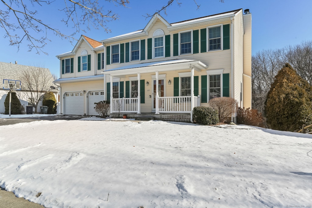 colonial inspired home with a garage and a porch