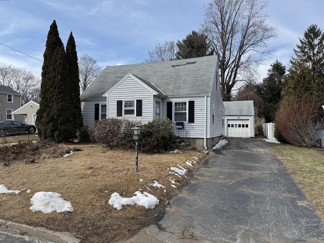 view of front of house with driveway, roof with shingles, and an outbuilding