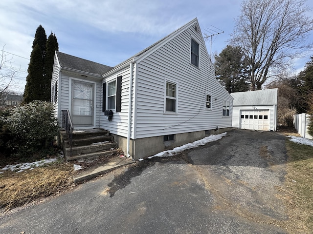 view of front of house with an outbuilding, driveway, roof with shingles, and a garage