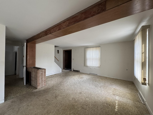 carpeted empty room with visible vents, stairway, beam ceiling, and baseboards