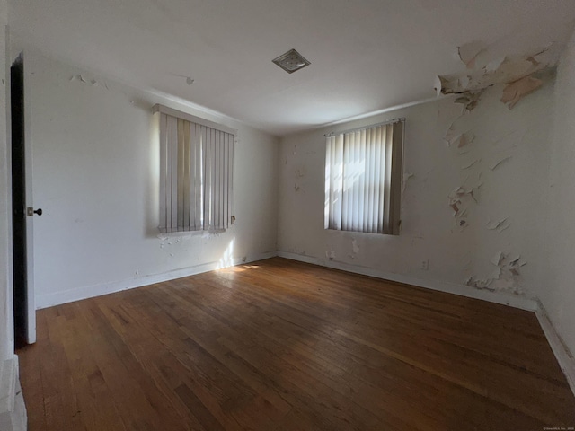 empty room with dark wood-style floors and baseboards