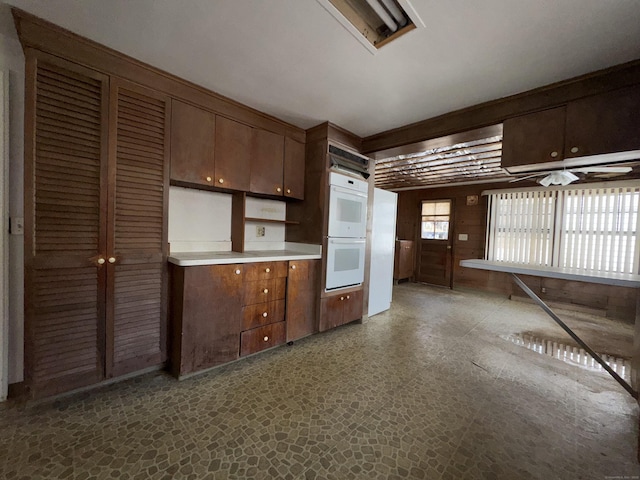 kitchen featuring light countertops, white double oven, and dark brown cabinets